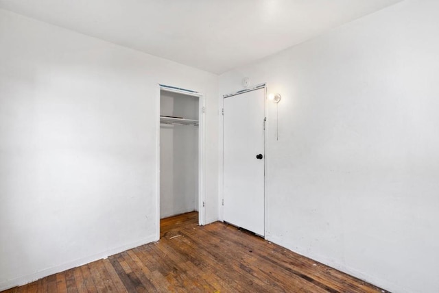 unfurnished bedroom featuring dark hardwood / wood-style flooring and a closet