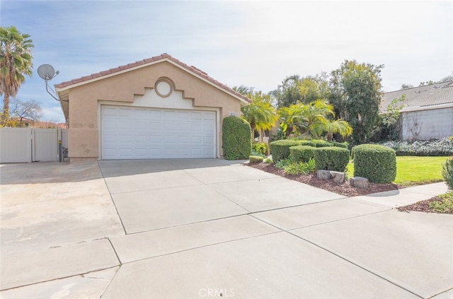 exterior space with a garage, driveway, fence, and stucco siding