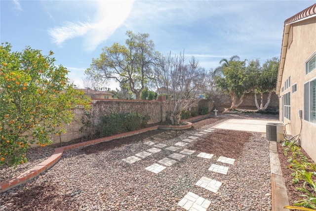 view of yard featuring a patio area, a fenced backyard, and central AC