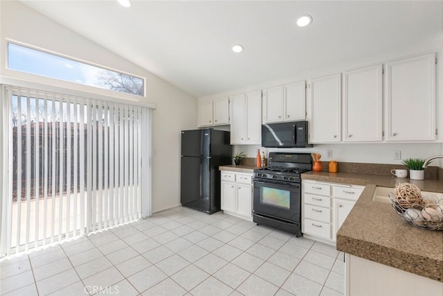 kitchen featuring white cabinets, lofted ceiling, black appliances, a sink, and light tile patterned flooring