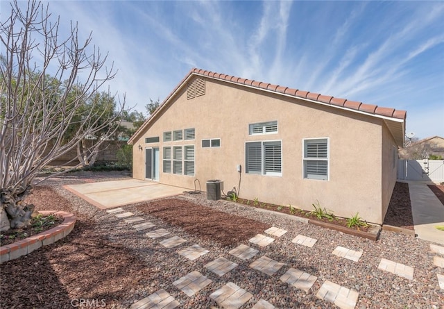 rear view of house featuring a patio, cooling unit, fence, and stucco siding