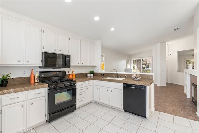 kitchen featuring visible vents, white cabinets, a sink, a peninsula, and black appliances