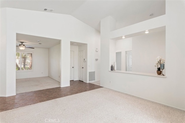 carpeted spare room with a ceiling fan, visible vents, and high vaulted ceiling