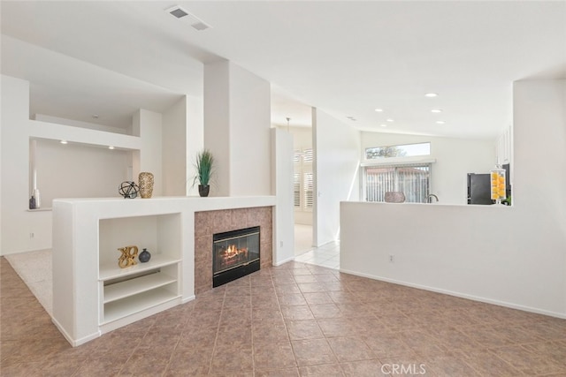 unfurnished living room featuring baseboards, visible vents, lofted ceiling, a fireplace, and recessed lighting