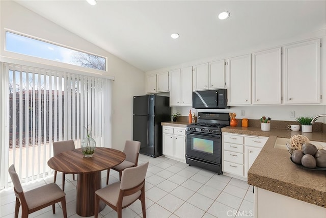 kitchen featuring lofted ceiling, black appliances, white cabinets, and a sink