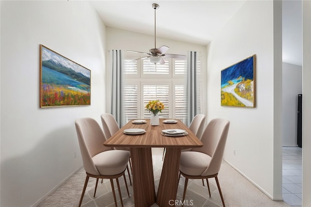 dining room featuring baseboards, a ceiling fan, and light colored carpet