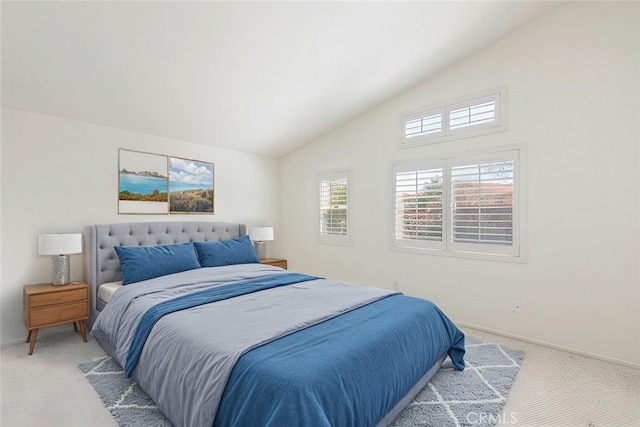 bedroom with light carpet, lofted ceiling, and baseboards