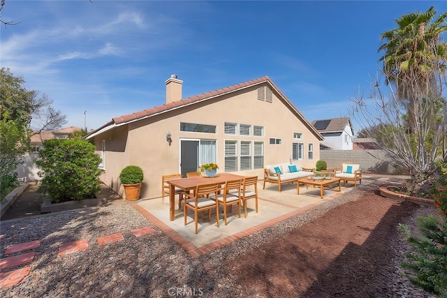 rear view of house featuring a patio area, a chimney, fence, and an outdoor living space