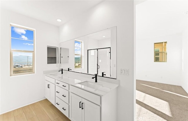 bathroom featuring vanity, hardwood / wood-style floors, and a shower with shower door