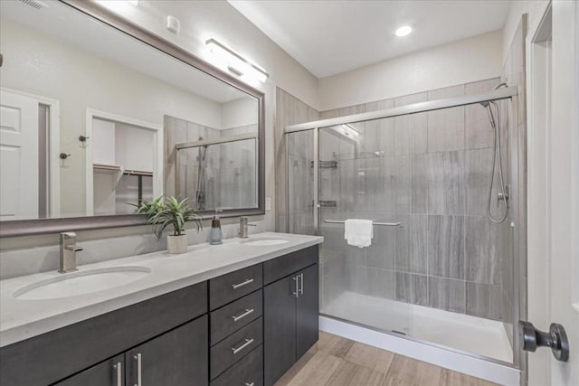 bathroom featuring hardwood / wood-style flooring, vanity, and a shower with shower door