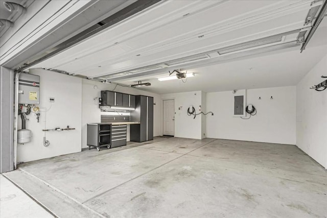 garage featuring tankless water heater, a garage door opener, and electric panel