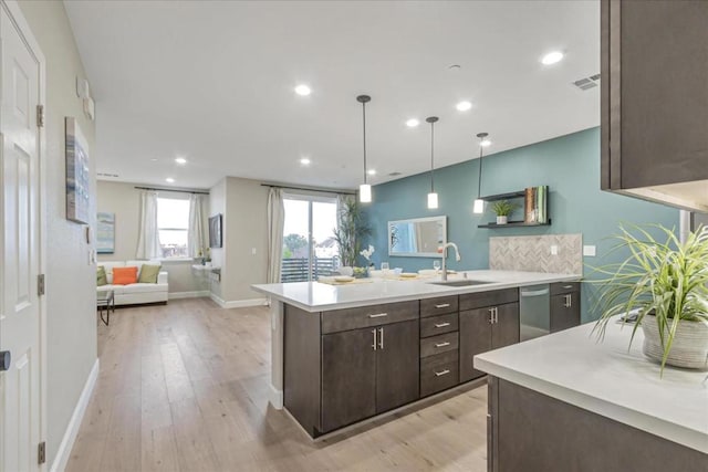 kitchen with sink, light hardwood / wood-style flooring, dishwasher, dark brown cabinetry, and decorative light fixtures