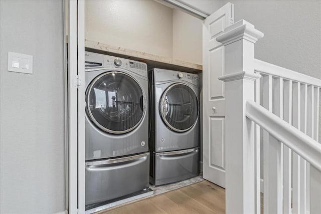 laundry area with washer and dryer and light wood-type flooring