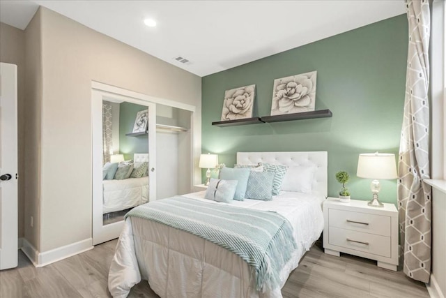 bedroom with light hardwood / wood-style floors and a closet