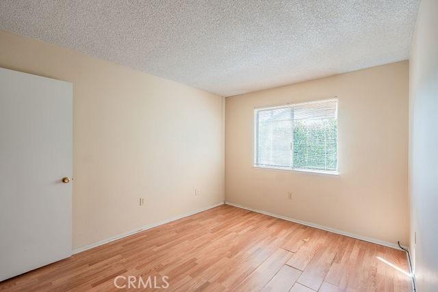 unfurnished room with a textured ceiling and light hardwood / wood-style floors