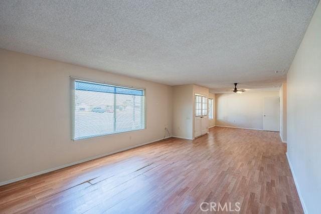 spare room with ceiling fan, light hardwood / wood-style floors, and a textured ceiling