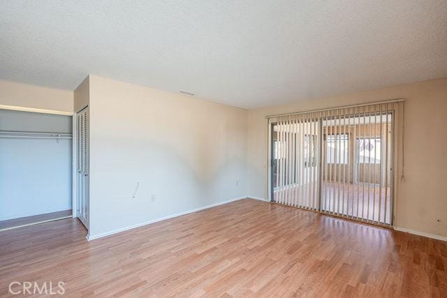 unfurnished bedroom with a closet, light hardwood / wood-style flooring, and a textured ceiling