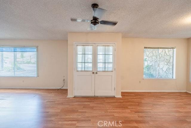 entryway featuring french doors, a textured ceiling, ceiling fan, and light hardwood / wood-style flooring