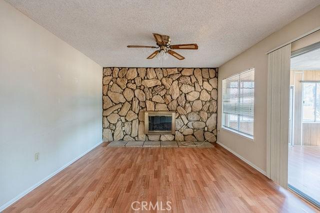 unfurnished living room featuring light hardwood / wood-style flooring, a fireplace, and a textured ceiling