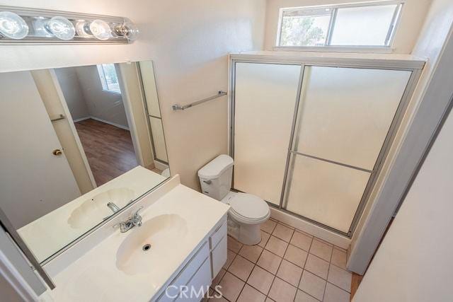 bathroom featuring vanity, plenty of natural light, tile patterned floors, and a shower with shower door