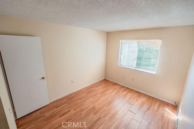 empty room featuring light hardwood / wood-style floors and a textured ceiling