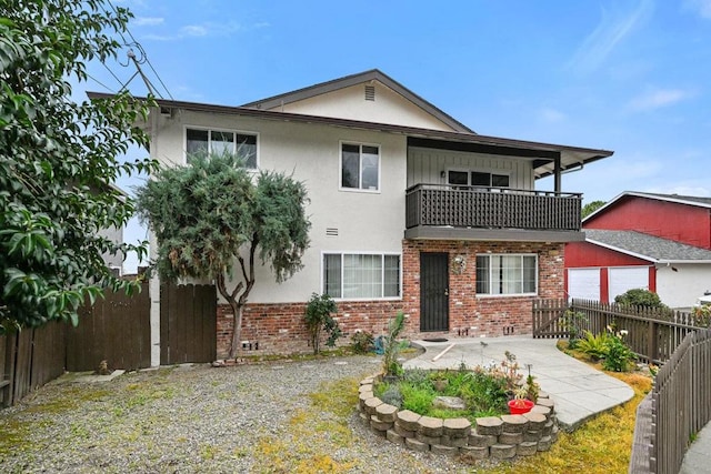 view of front of property featuring a garage and a balcony