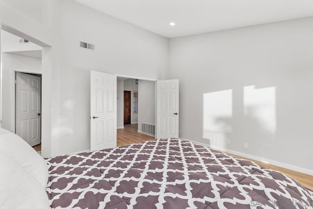 unfurnished bedroom with hardwood / wood-style flooring and a high ceiling