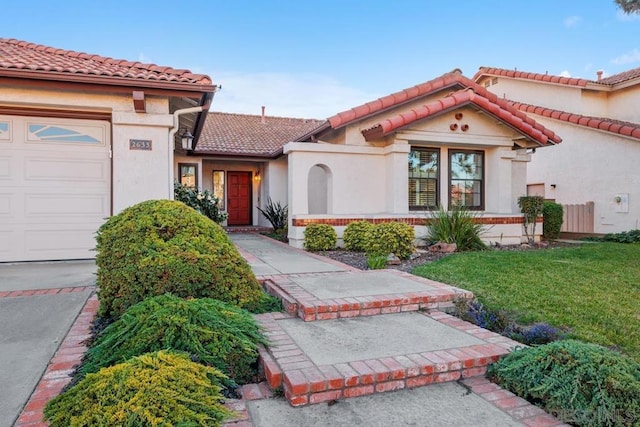 mediterranean / spanish home featuring a garage and a front yard