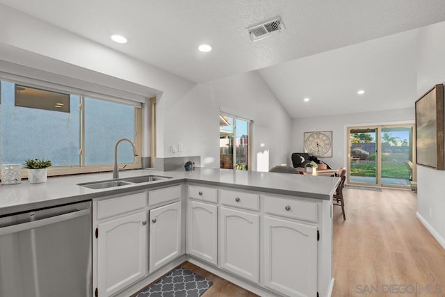 kitchen featuring dishwasher, sink, white cabinets, kitchen peninsula, and light hardwood / wood-style flooring