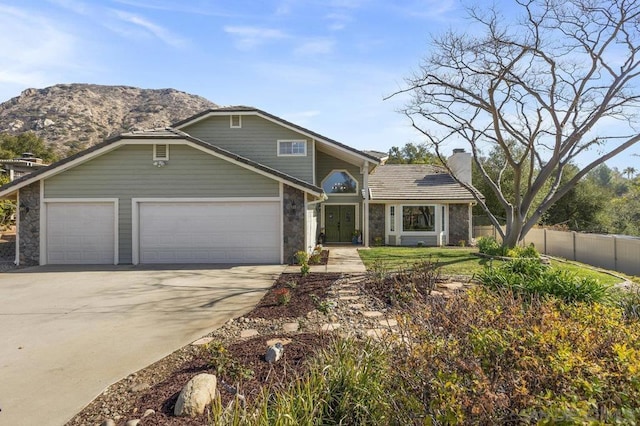 front of property with a garage and a mountain view