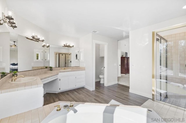 bathroom with vanity, hardwood / wood-style flooring, toilet, and walk in shower