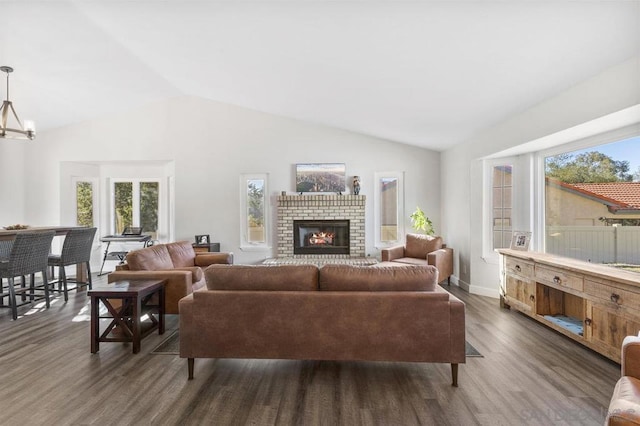 living room featuring lofted ceiling, a healthy amount of sunlight, and dark wood-type flooring