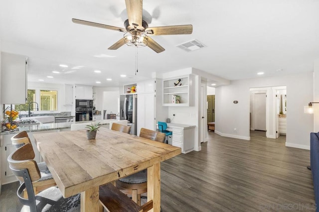 dining space with ceiling fan, dark hardwood / wood-style flooring, and sink