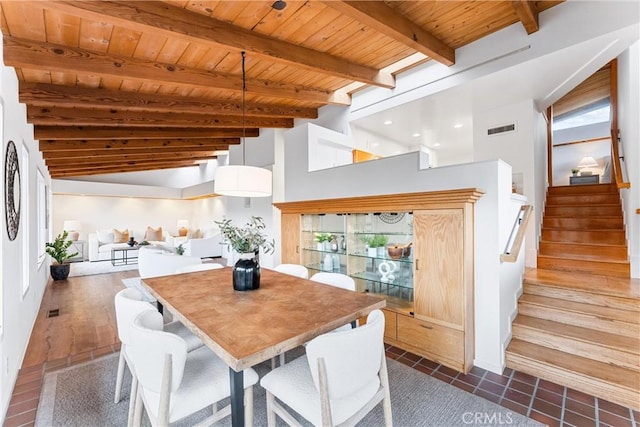 dining room featuring vaulted ceiling with beams, stairway, wooden ceiling, and visible vents