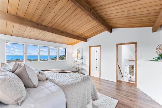 bedroom featuring wood ceiling, vaulted ceiling with beams, hardwood / wood-style flooring, and a water view