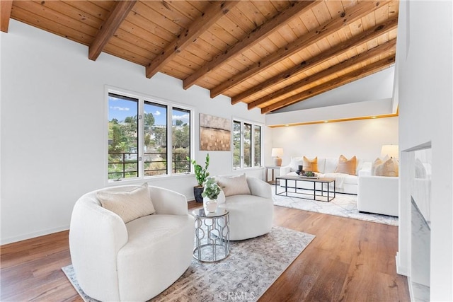 sitting room with wood ceiling, vaulted ceiling with beams, baseboards, and wood finished floors