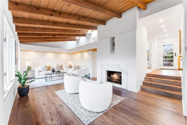 living room with recessed lighting, a premium fireplace, wood finished floors, wood ceiling, and beamed ceiling