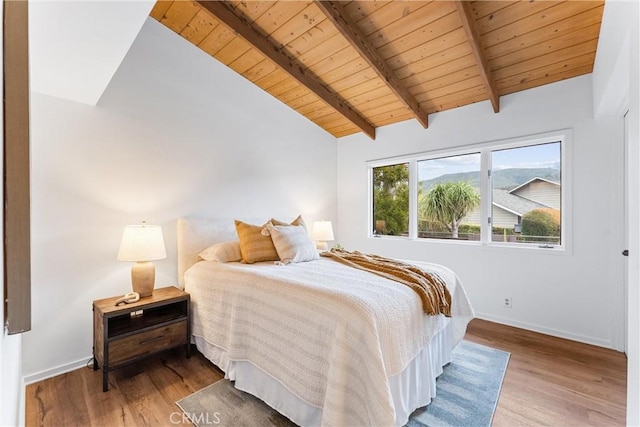 bedroom with lofted ceiling with beams, hardwood / wood-style floors, and wood ceiling