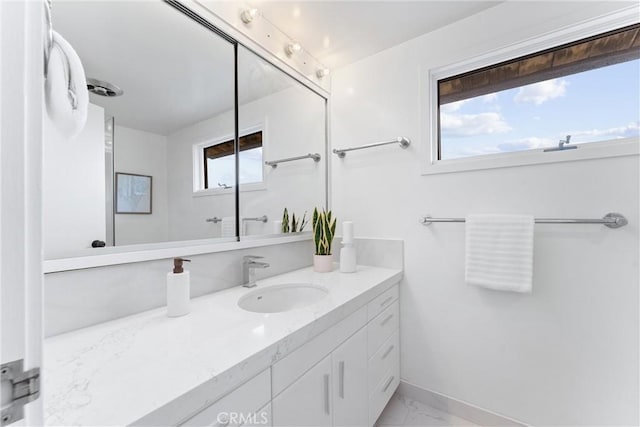 bathroom featuring marble finish floor, vanity, and baseboards