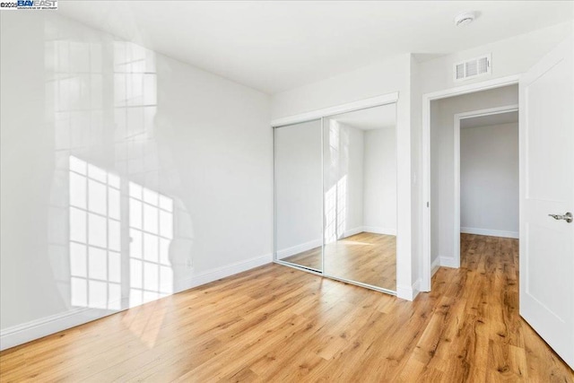 unfurnished bedroom featuring a closet and light hardwood / wood-style flooring