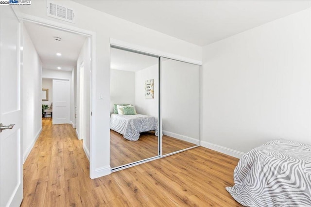 bedroom with wood-type flooring and a closet