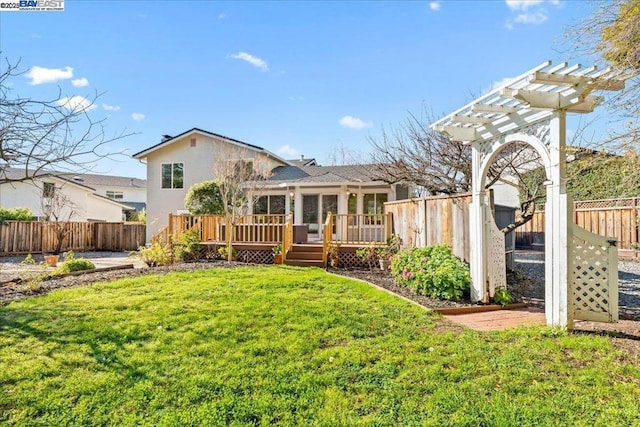 back of house with a yard, a deck, and a pergola