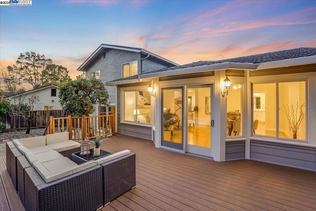 deck at dusk with an outdoor hangout area