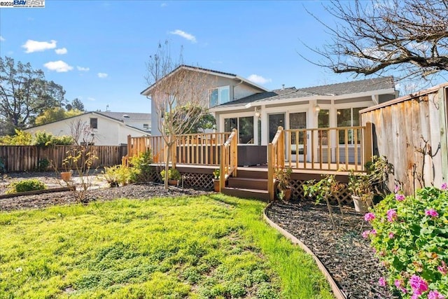 back of property featuring a yard and a deck