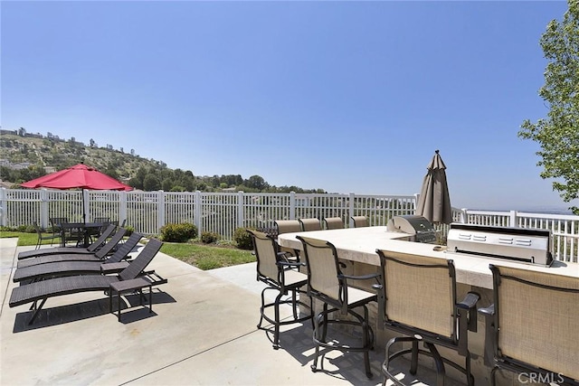 view of patio / terrace featuring outdoor dining area, fence, and outdoor dry bar