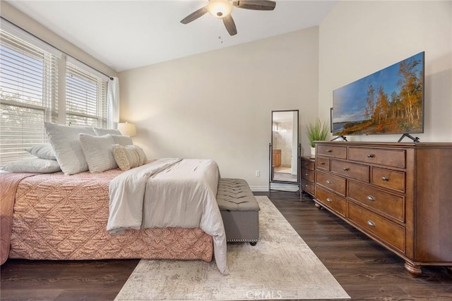 bedroom with ceiling fan, ensuite bath, lofted ceiling, and dark wood-style flooring