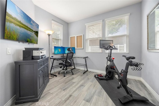 office with baseboards and light wood-style flooring