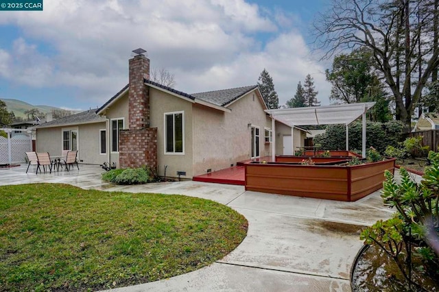 rear view of property featuring a yard, a pergola, and a patio area