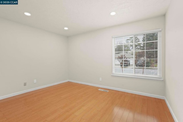 spare room with hardwood / wood-style floors