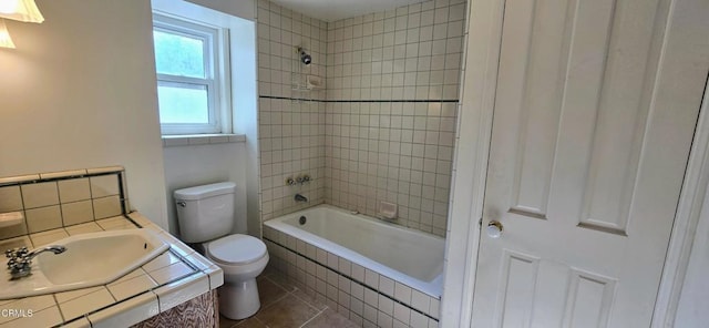 full bathroom featuring vanity, tiled shower / bath combo, tile patterned floors, and toilet